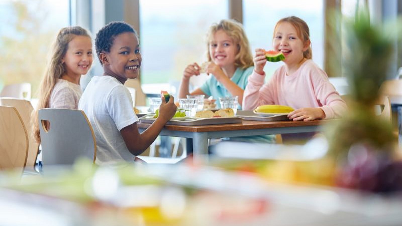Vier Mädchen essen zusammen in der Mensa