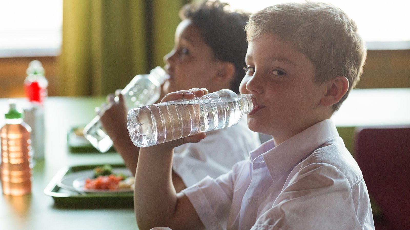 2 Jungen trinken Wasser in der Schule 