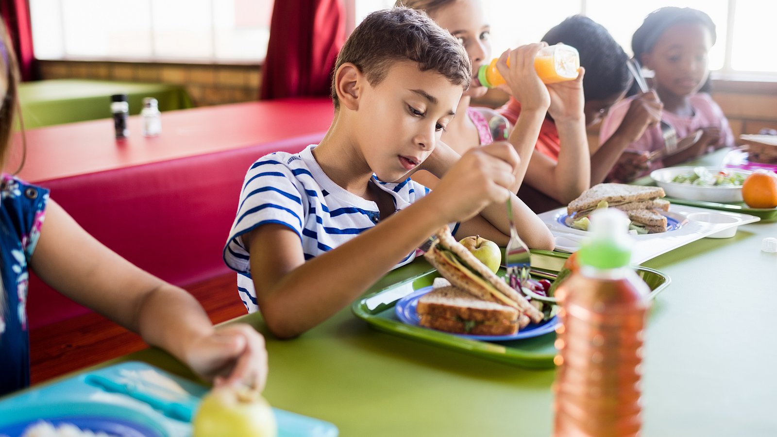 Kinder beim Mittagessen in der Schulmensa