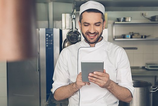 Koch guckt im Tablet nach