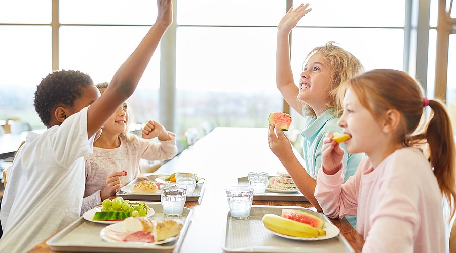 zufriedene Schulkinder beim Mittagessen