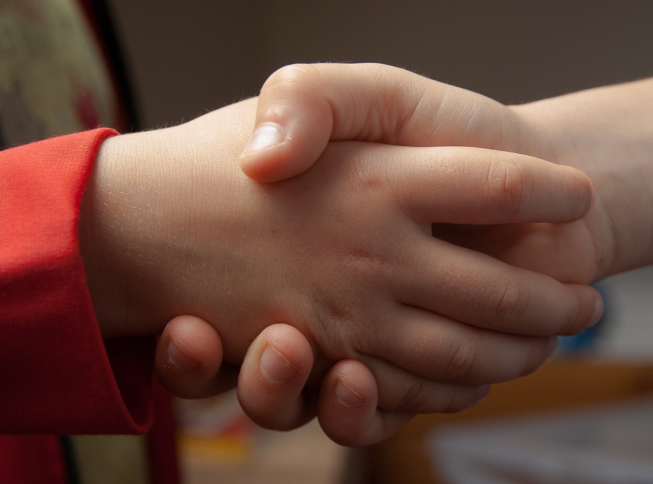 Kinder geben sich die Hand